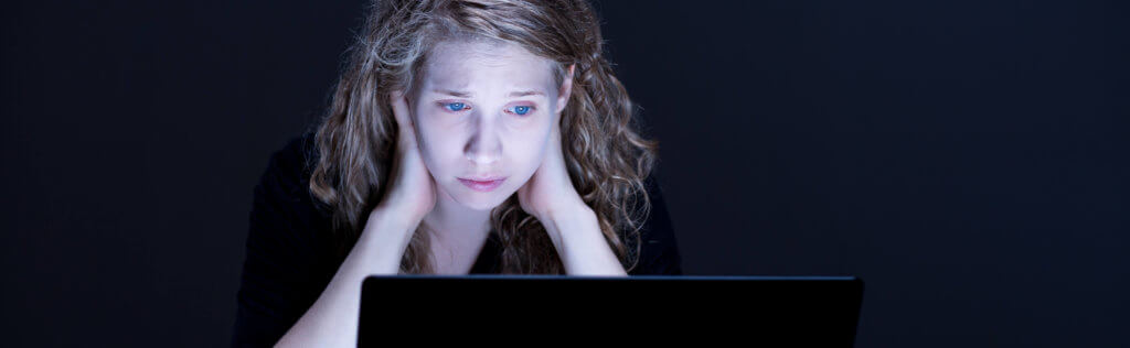 Despair sad girl looking at computer's screen